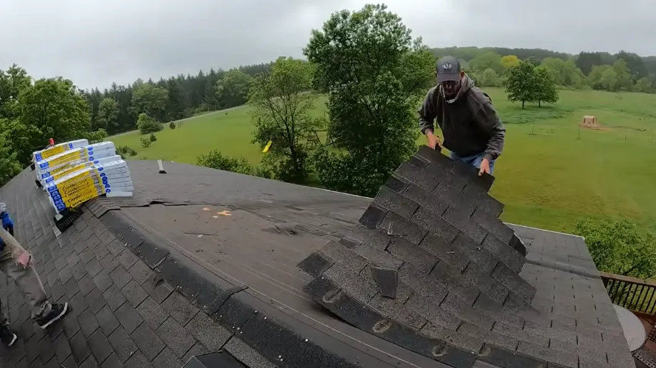 Pile of torn-off old shingles as a roofer clears the roof for new roofing